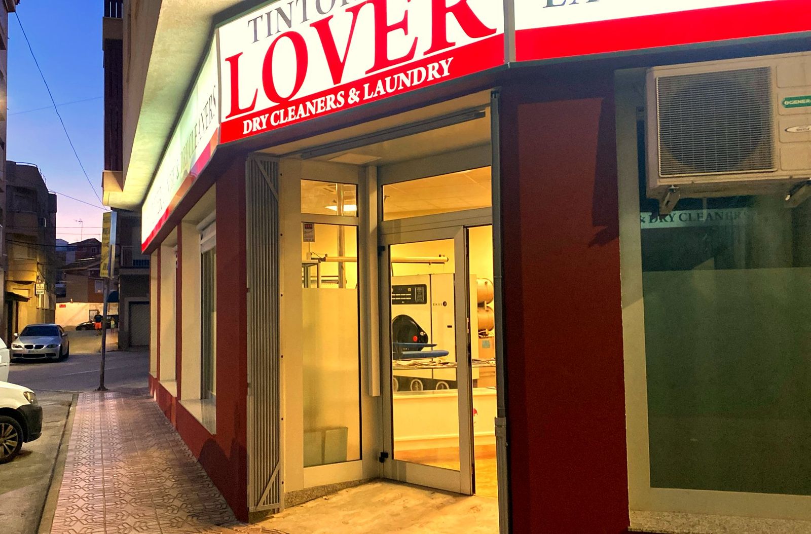 Fachada de Tintorería Lover con el rótulo iluminado